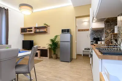 a kitchen with a refrigerator and a table with chairs at Vatican Bells with Balcony View of St Peters Dome Two Bedrooms Two Bathrooms in Rome
