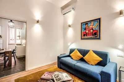 a living room with a blue couch and a table at MONTI QUIET AND SPACIOUS APARTMENT in Rome