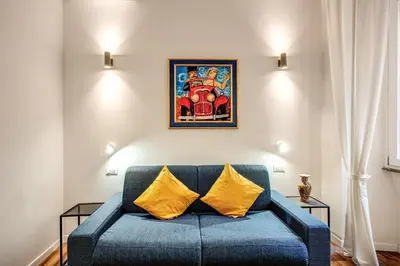a blue couch with two yellow pillows in a living room at MONTI QUIET AND SPACIOUS APARTMENT in Rome