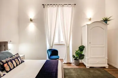 a bedroom with a bed and a blue chair at MONTI QUIET AND SPACIOUS APARTMENT in Rome