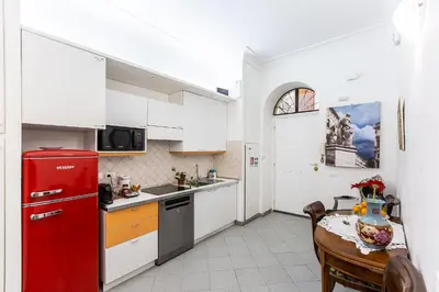 a kitchen with a red refrigerator and a table at Gianicolo Holiday House in Rome