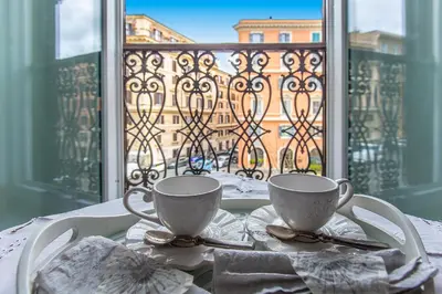 a table with two coffee cups on a table in front of a window at Gianicolo Holiday House in Rome