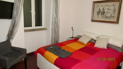 a bedroom with a colorful bed and a chair at Vatican Apartment in Rome