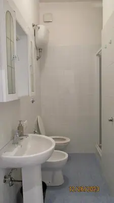 a white bathroom with a sink and a toilet at Vatican Apartment in Rome