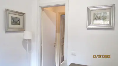 a hallway with a mirror and two pictures on the wall at Vatican Apartment in Rome
