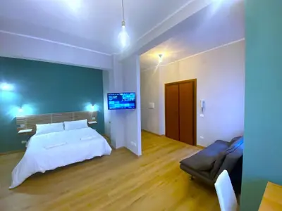 a bedroom with a bed and a couch and a television at Monolocale Urban House Marconi in Rome