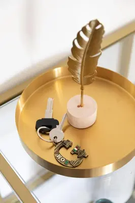 a gold table with a feather and keys on it at G & G Maisonette Testaccio in Rome