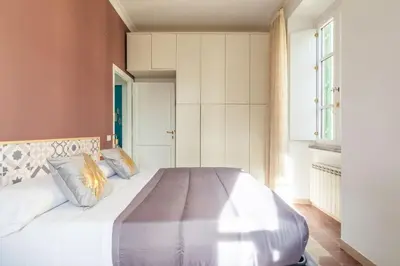 a bedroom with a large bed with white sheets at G & G Maisonette Testaccio in Rome