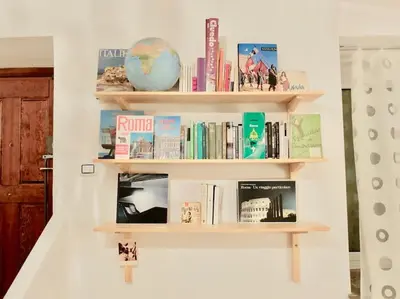 a book shelf with books and a globe on it at Vintage in Trastevere in Rome