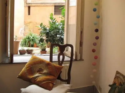 a chair with a pillow in a room with a window at Vintage in Trastevere in Rome