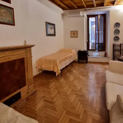 a living room with a bed and a tv at Casa Nicoletta in Rome