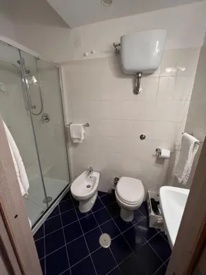a bathroom with a shower and a toilet and a sink at Guest House Biondi Cavour in Rome