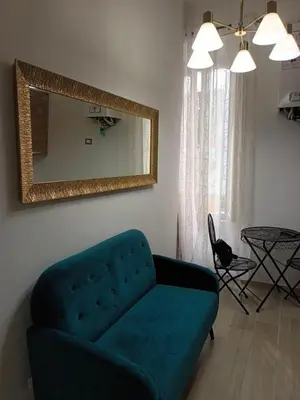a living room with a blue couch and a mirror at Guest House Biondi Cavour in Rome