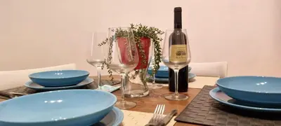 a table with plates and glasses and a bottle of wine at Zaira's House - Largo Argentina Campo de’ fiori in Rome
