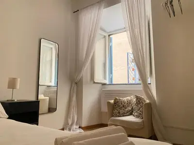 a bedroom with a window and a chair and a mirror at Zaira's House - Largo Argentina Campo de’ fiori in Rome