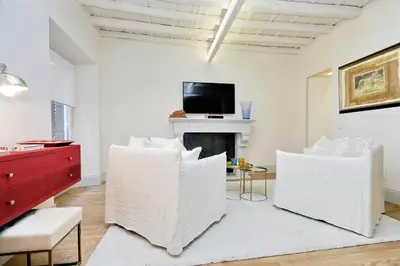 a living room with white chairs and a fireplace at Luxury Charme between Pantheon and Spanish Steps in Rome