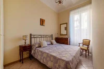 a bedroom with a bed and a chair and a window at GuestHost - The secret garden of Rome! Apt x2 in Rome