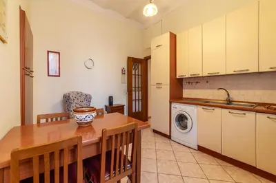 a kitchen with a table and a washing machine at GuestHost - The secret garden of Rome! Apt x2 in Rome