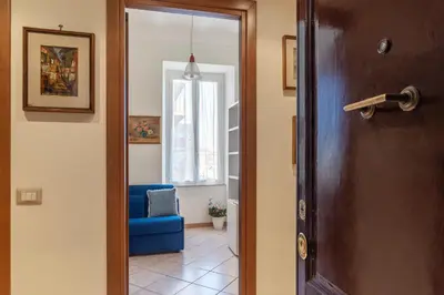 a door leading into a room with a blue chair at GuestHost - The secret garden of Rome! Apt x2 in Rome