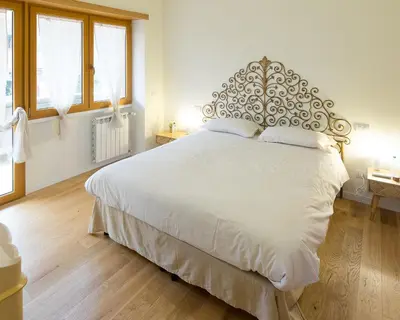 a bedroom with a large white bed with a metal headboard at Trastevere Andrea' s home in Rome