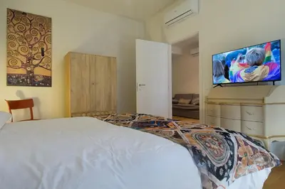 a bedroom with a bed and a flat screen tv at Trastevere Andrea' s home in Rome