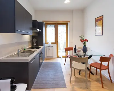 a kitchen and dining room with a table and chairs at Trastevere Andrea' s home in Rome