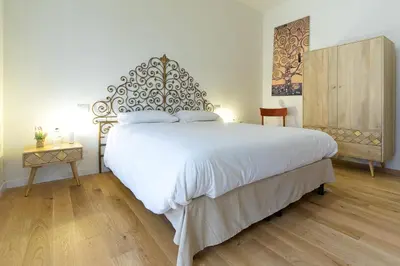 a bedroom with a large white bed and a table at Trastevere Andrea' s home in Rome