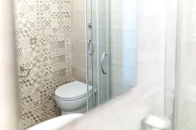 a bathroom with a toilet and a glass shower at Hotel Cathrine in Rome