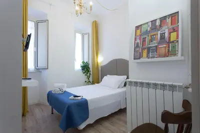 a small room with a bed and a table at Hotel Cathrine in Rome