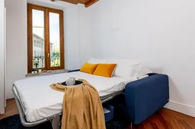 a bedroom with a bed and a blue chair at Panoramic Flat Barberini in Rome