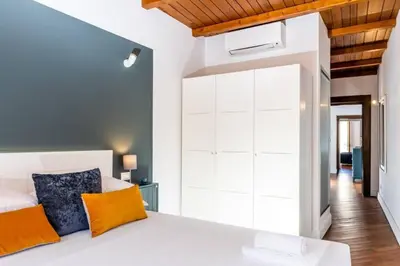 a bedroom with a white bed with orange pillows at Panoramic Flat Barberini in Rome