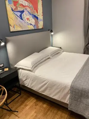 a bed in a bedroom with a painting on the wall at Tolemaide Orange Apartment in Rome