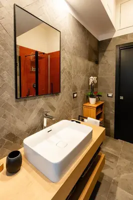 a bathroom with a white sink and a mirror at Tolemaide Orange Apartment in Rome