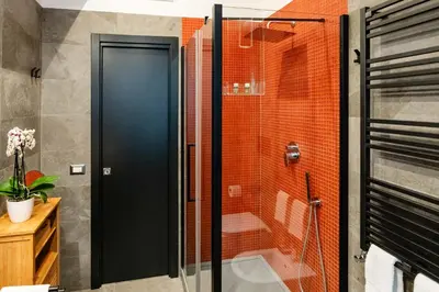 a shower with a glass door in a bathroom at Tolemaide Orange Apartment in Rome