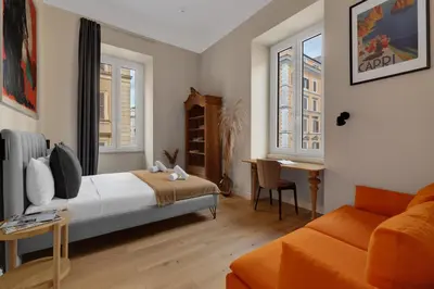 a bedroom with a bed and a couch and windows at ROME City Center Apartment II in Rome