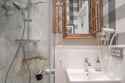 a bathroom with a sink and a shower with a mirror at ROME City Center Apartment II in Rome