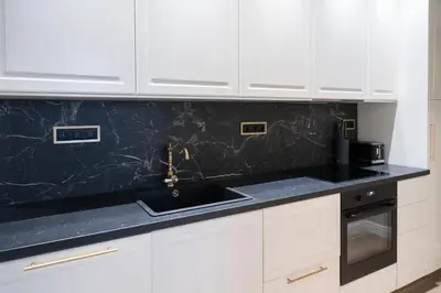 a kitchen with white cabinets and a black counter top at ROME City Center Apartment II in Rome