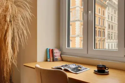 a table with a cup and a book and a window at ROME City Center Apartment II in Rome