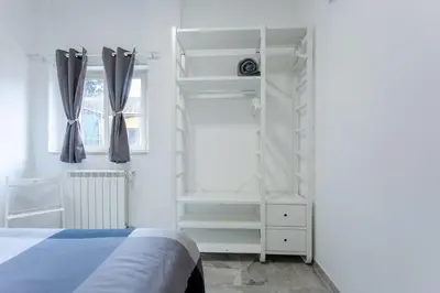 a bedroom with a bed and white shelves and a window at A casa di Elly 2 in Rome