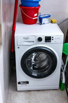 a white washing machine with a red bucket on top at Domus Marconi Roma in Rome
