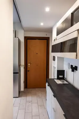 a kitchen with a counter and a wooden door at Domus Marconi Roma in Rome
