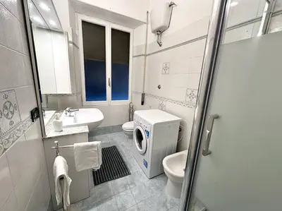a bathroom with a toilet sink and a washing machine at San Pietro city center close to the subway in Rome