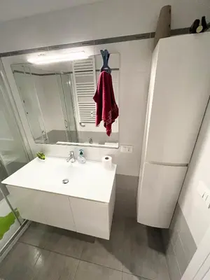 a white bathroom with a sink and a mirror at Cuore di Testaccio Apartment 2 in Rome