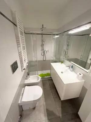 a white bathroom with a toilet and a sink at Cuore di Testaccio Apartment 2 in Rome