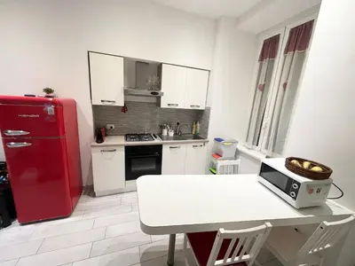 a kitchen with a red refrigerator and a table with a microwave at Cuore di Testaccio Apartment 2 in Rome