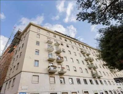 a tall white building with flower boxes on it at Domus Testaccio in Rome