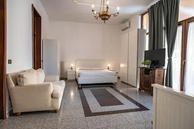 a bedroom with a bed and a couch and a chair at Domus Pretorio in Rome