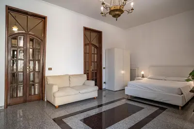 a bedroom with a bed and a couch and a chair at Domus Pretorio in Rome