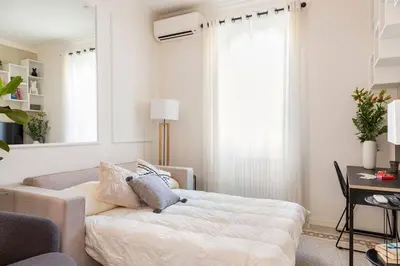a white living room with a bed and a desk at Your Cozy Home in Rome- Gemelli- close to downtown in Rome