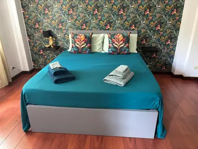a bed with a blue blanket and two towels on it at Pamphili212 in Rome